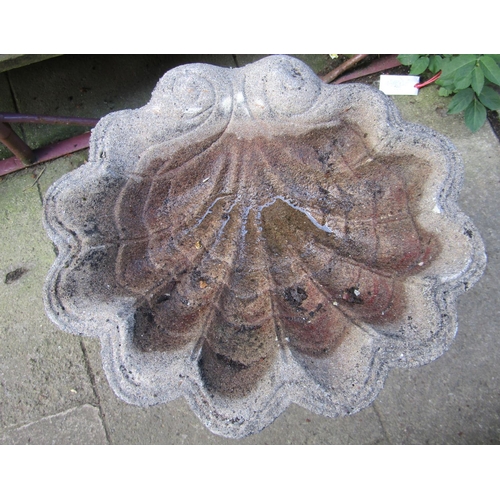 1073 - A weathered cast composition stone bird bath, the scallop shell shaped bowl raised on a fluted pedes... 