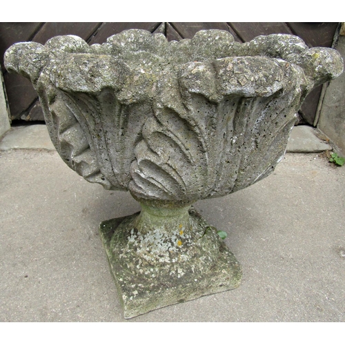 1083 - A weathered cast composition stone garden urn with circular acanthus leaf bowl and loose socle with ... 