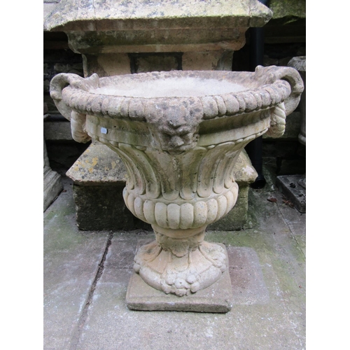 1084 - A weathered cast composition stone garden urn with circular lobed and fluted body, flared gadrooned ... 