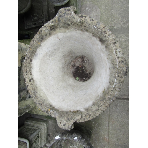 1084 - A weathered cast composition stone garden urn with circular lobed and fluted body, flared gadrooned ... 