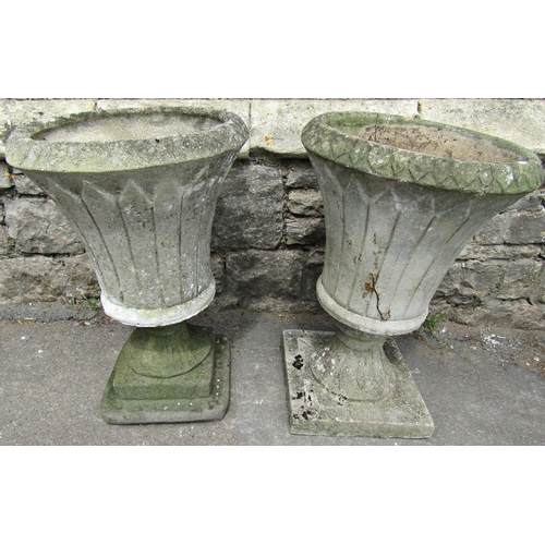 1085 - Two similar weathered cast composition stone garden urns of circular tapered form with flared repeat... 