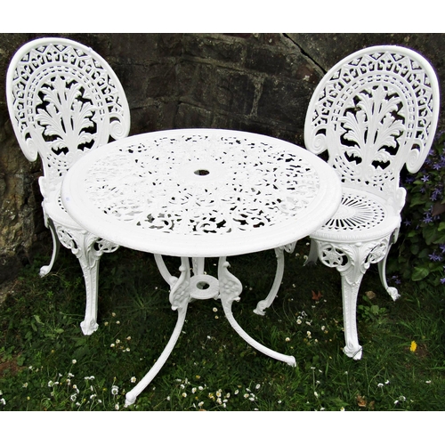 1099 - A cream painted cast aluminium garden terrace table of circular form with decorative pierced top rai... 