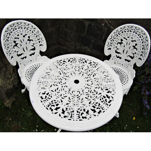 1099 - A cream painted cast aluminium garden terrace table of circular form with decorative pierced top rai... 