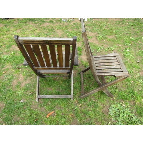 1064 - A weathered hardwood circular topped garden table with slatted panels raised on x framed folding sup... 