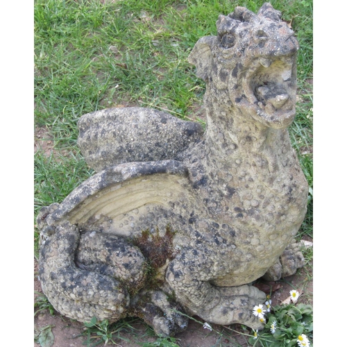 1127 - A weathered cast composition stone garden ornament in the form of a seated dragon with raised head 4... 