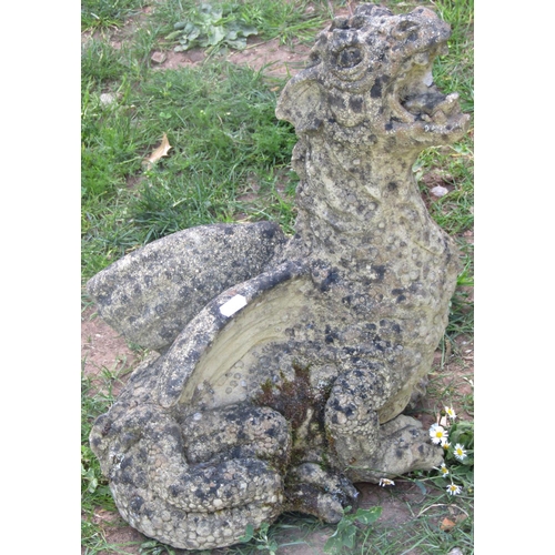 1127 - A weathered cast composition stone garden ornament in the form of a seated dragon with raised head 4... 