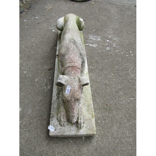 1148 - A weathered cast composition stone garden ornament in the form of a recumbent sleeping greyhound set... 