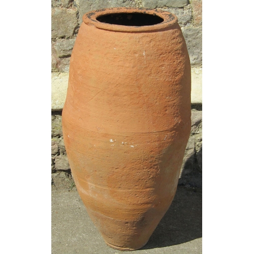 1162 - A terracotta slender oviform olive type jar/urn approximately 36 cm diameter x 80 cm high