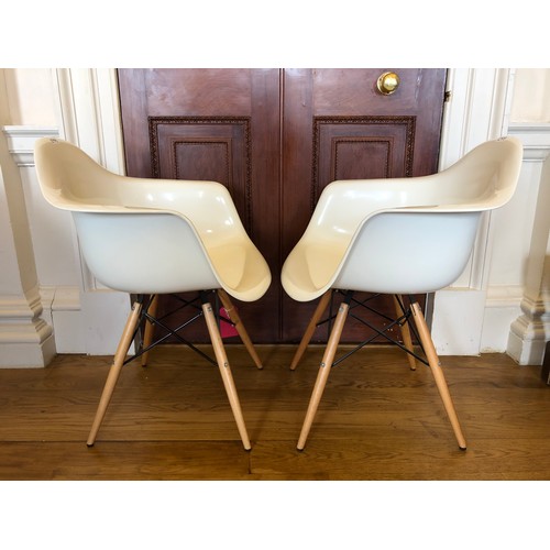 299 - A pair of DAW armchairs by Vitra after a design by Eames - in a white colourway set on beechwood sup... 