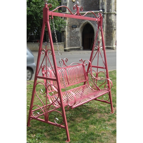 1083 - An ironwork two seat garden swing with strapwork seat and back, chain hung and raised on A framed su... 