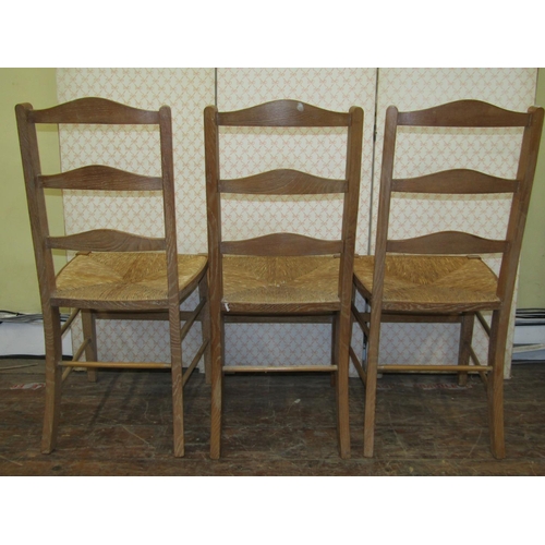 1671 - A Harlequin set of three pale oak ladderback chairs, almost certainly Heals, with rush seats n squar... 