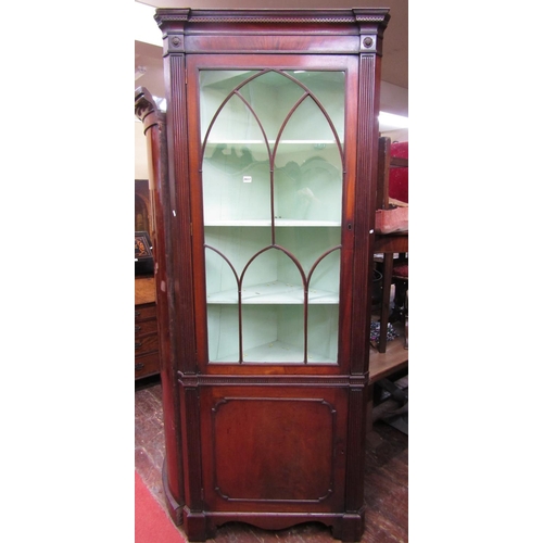 1673 - A Georgian mahogany free standing corner cupboard, the lower section enclosed by a panelled door, th... 