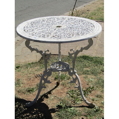 1090 - A cream painted cast aluminium garden terrace table of circular form, with decorative pierced scroll... 