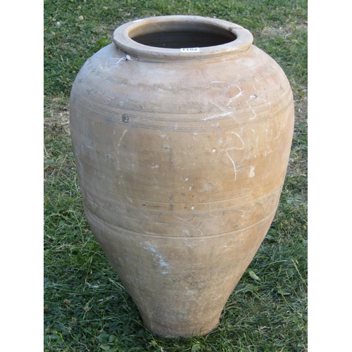 1102 - A vintage terracotta olive jar with simple incised bands and combed detail, 60cm high approx