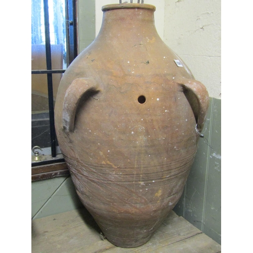 1104 - An old weathered terracotta oviform jar with two moulded loop handles, probably designed to carry or... 