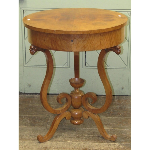 1654 - A 19th century Biedermeier ladies sewing table of circular form, the rising lid revealing a fitted i... 