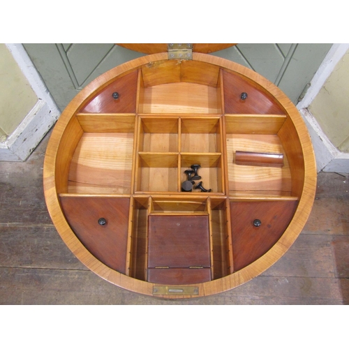 1654 - A 19th century Biedermeier ladies sewing table of circular form, the rising lid revealing a fitted i... 