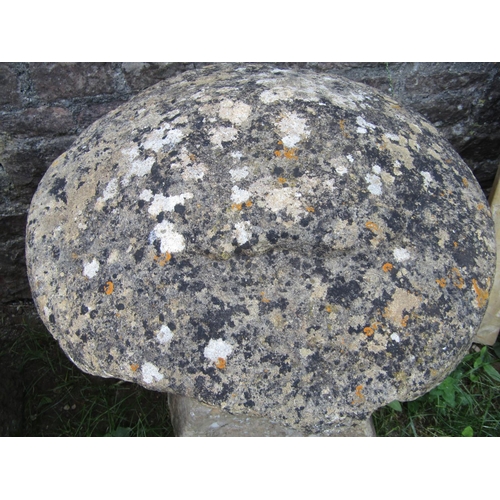 1063 - A weathered natural stone staddlestone of square tapered form with domed cap, approx 60cm diameter x... 