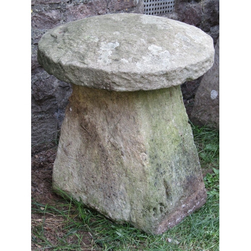 1065 - A weathered natural stone staddlestone of tapered form beneath a domed cap, 55cm diameter x 60cm hig... 