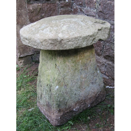 1065 - A weathered natural stone staddlestone of tapered form beneath a domed cap, 55cm diameter x 60cm hig... 