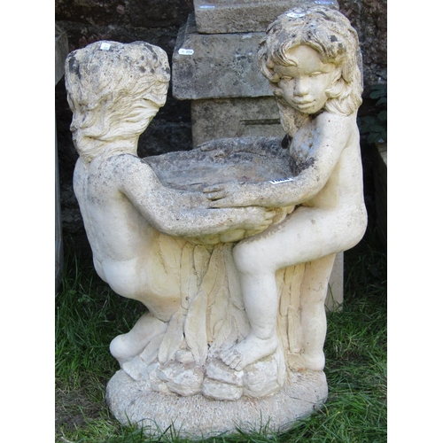 1068 - A weathered cast composition stone bird bath in the form of children clutching a fluted bowl, raised... 