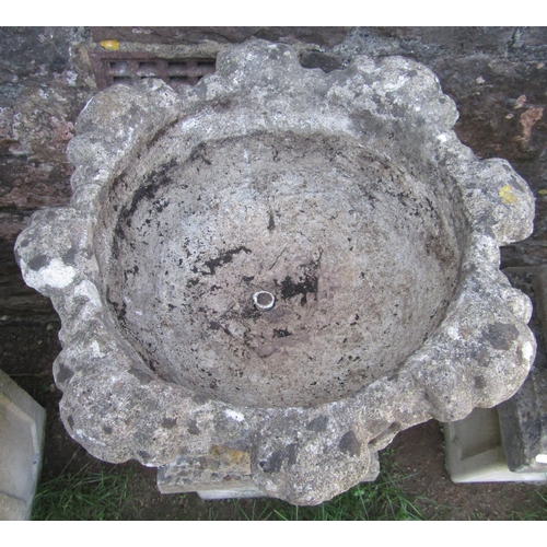 1069 - A pair of weathered cast composition stone garden urns, with circular acanthus leaf bowls raised on ... 