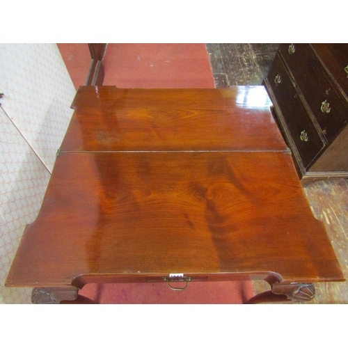 1643 - A Georgian mahogany foldover top tea table with turret corners, set on four carved supports, enclosi... 