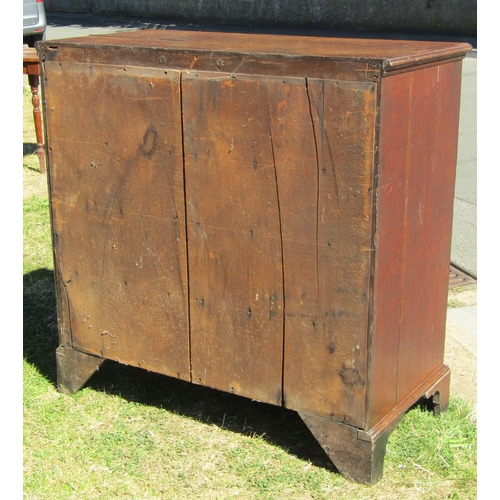 1633 - A late Georgian oak chest of three long and two short graduated drawers, crossbanded in walnut, rais... 