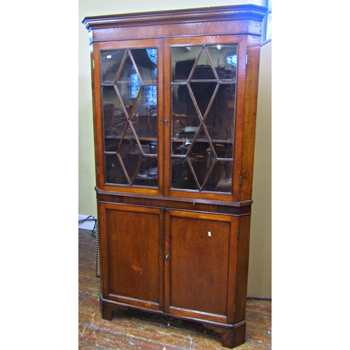 1665 - A Georgian oak free standing corner cupboard, the lower section enclosed by a pair of panelled doors... 