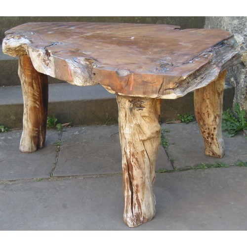 1683 - A rustic occasional table the heavy top taking the shape of the trunk, raised on three branch suppor... 