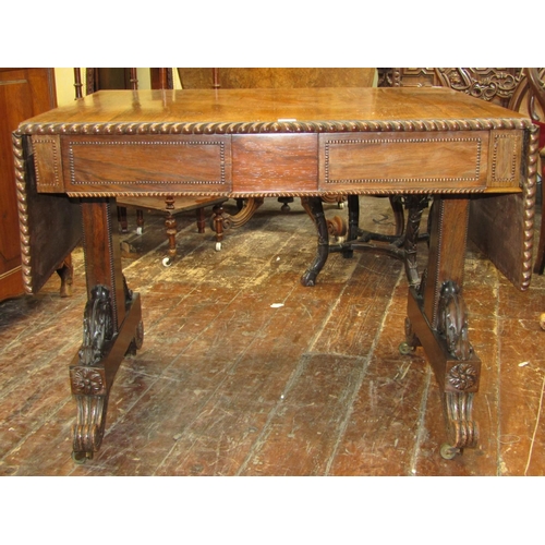 1659 - A Regency rosewood sofa table, raised on a stretcher base, the top with gadrooned borders, the base ... 