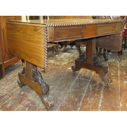 1659 - A Regency rosewood sofa table, raised on a stretcher base, the top with gadrooned borders, the base ... 