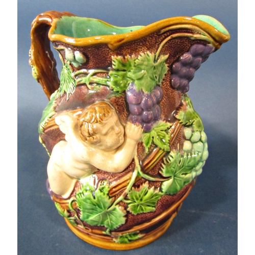 41 - A 19th century majolica jug with deep relief moulded detail showing a cherub amongst fruiting vines,... 