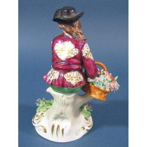 73 - A Sitzendorf figure of a seated gentleman with a basket of flowers and floral encrusted decoration w... 