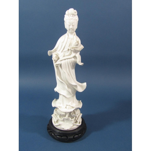 74 - A Blanc De Chine figure of a Buddhistic type character set upon a lotus flower base with wooden plin... 