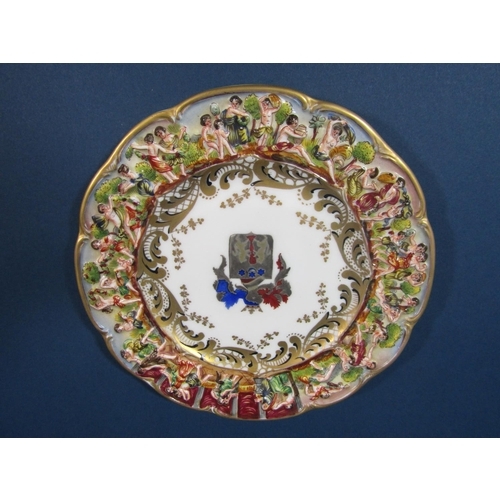 68 - A Capodimonte armorial plate with elaborate decoration to the rim in low relief depicting dancing an... 