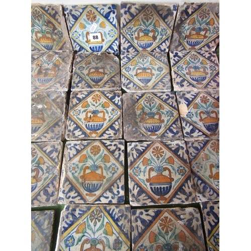 88 - A collection of 40 antique Isnic ceramics tiles, with repeating detail centered around a vase of flo... 