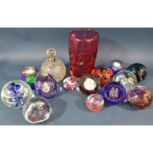 125 - Twelve Caithness paperweights of varying shapes and sizes, a red glass vase and a cut glass scent bo... 