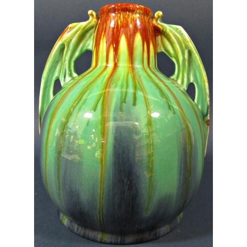 83a - An art deco style pottery vase of low form with drawn neck, drip glazed finish in blue, green turquo... 