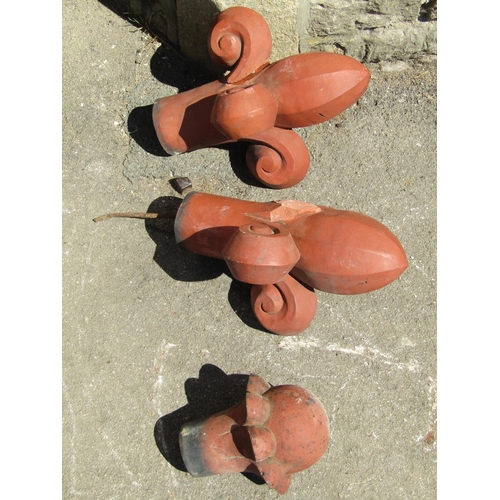 1073 - A pair of reclaimed terracotta faceted plume terracotta ridge finials together with one other (af), ... 