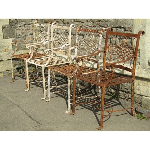 1075 - A set of four old iron strapwork garden chairs, with entwined and scrolled backs and lattice seats o... 