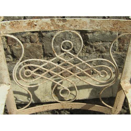 1075 - A set of four old iron strapwork garden chairs, with entwined and scrolled backs and lattice seats o... 