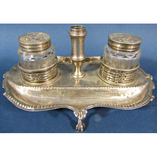 209 - A Georgian silver desk stand, with two capped glass inkwells and a central pen holder with beaded de... 