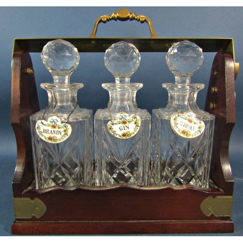 142 - An Edwardian style mahogany tantalus with three decanters with Coalport china labels, Whisky, Gin an... 