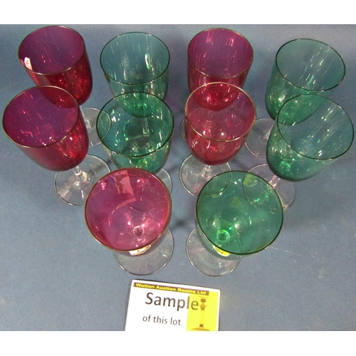 144 - Twenty five cranberry red baluster wine glasses on slender stems, and eight green baluster wine glas... 