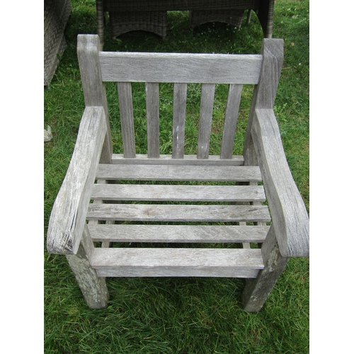 1046 - A weathered heavy gauge teak garden open armchair with slatted seat and back, 70 cm wide