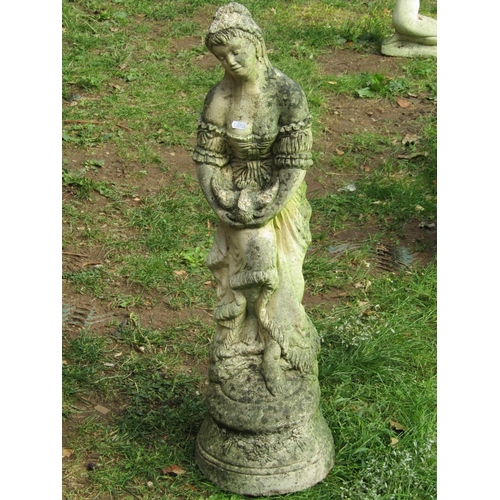 1051 - A weathered cast composition stone garden ornament in the form of a standing maiden releasing a bird... 