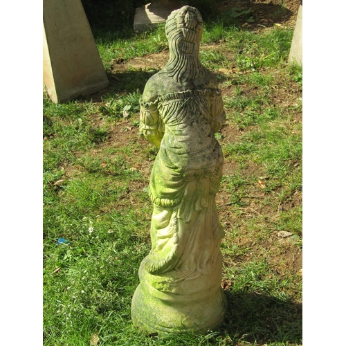 1051 - A weathered cast composition stone garden ornament in the form of a standing maiden releasing a bird... 