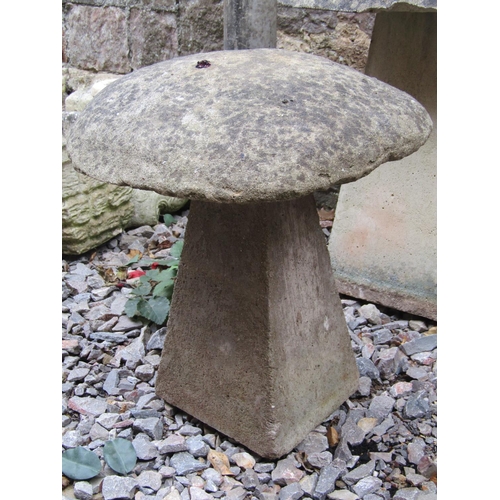 1052 - A weathered cast composition stone staddle stone and cap, 58 cm high, together with a similar matchi... 