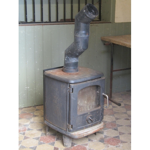 1092 - A Morso cast iron wood burning stove enclosed by a partially glazed panelled door